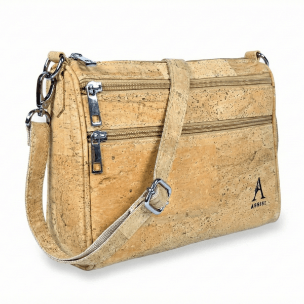 Beige cork-textured handbag with multiple zippers and a shoulder strap photographed on white background
